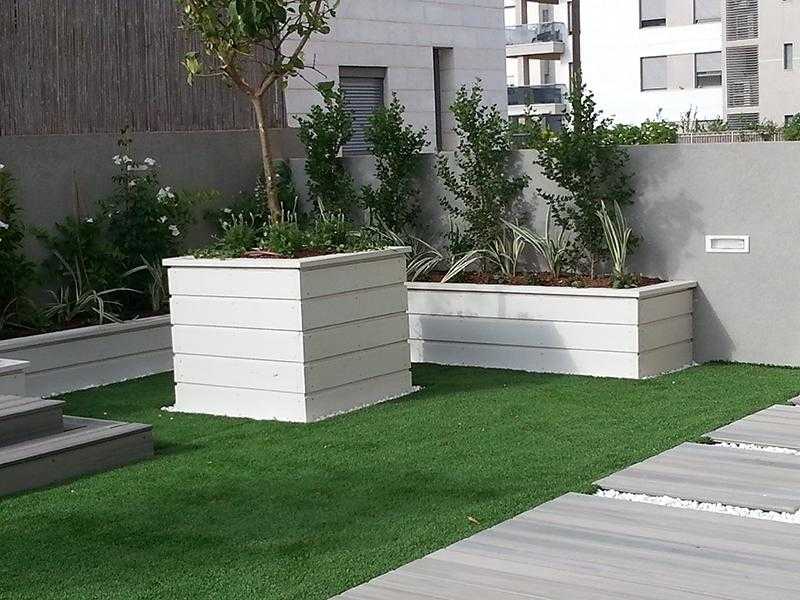 דשא סינטתי במת עץ מוגבהת ואדניות מובנות בגינת חצר
