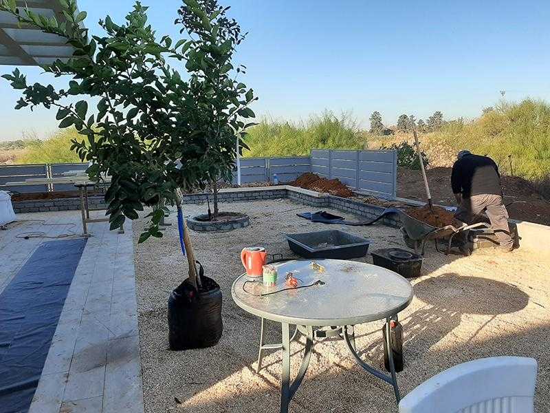 עבודה על גינת חצר סביב הבית