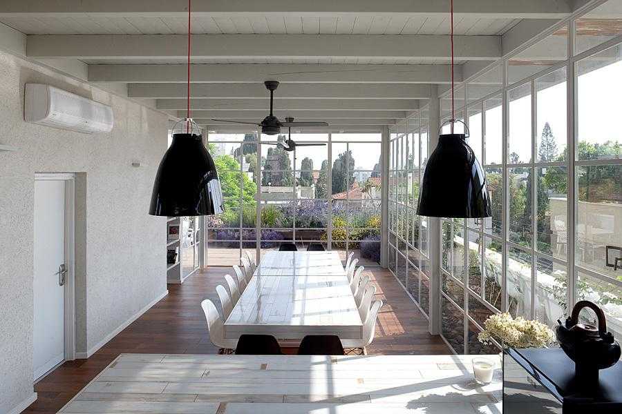 פרגולת עץ לבנה עם סגירת חלונות זכוכית בחצר הבית