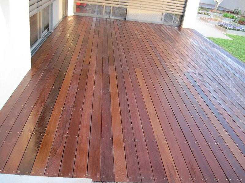 דק עץ בגינת חצר בשילוב דשא וחצץ עם אדניות מוגבהות