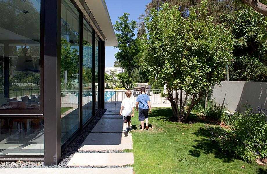 שילוב אבני מדרך רחבות בגינת חצר סביב הבית