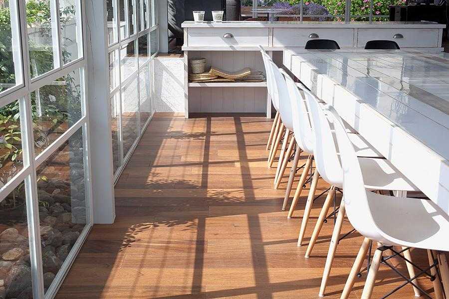 רצפת דק טבעי עם סגירת חלונות זכוכית בחצר הבית