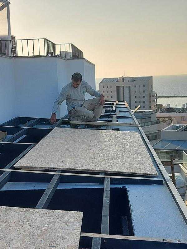 כיסוי עץ לפרגולת מתכת במרפסת על הגג