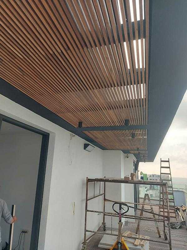 פרגולת עץ ומתכת בשילוב גופי תאורה במרפסת