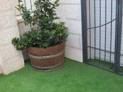 עצית מעוצב בצורת חבית מונח על גבי דשא סינטתי